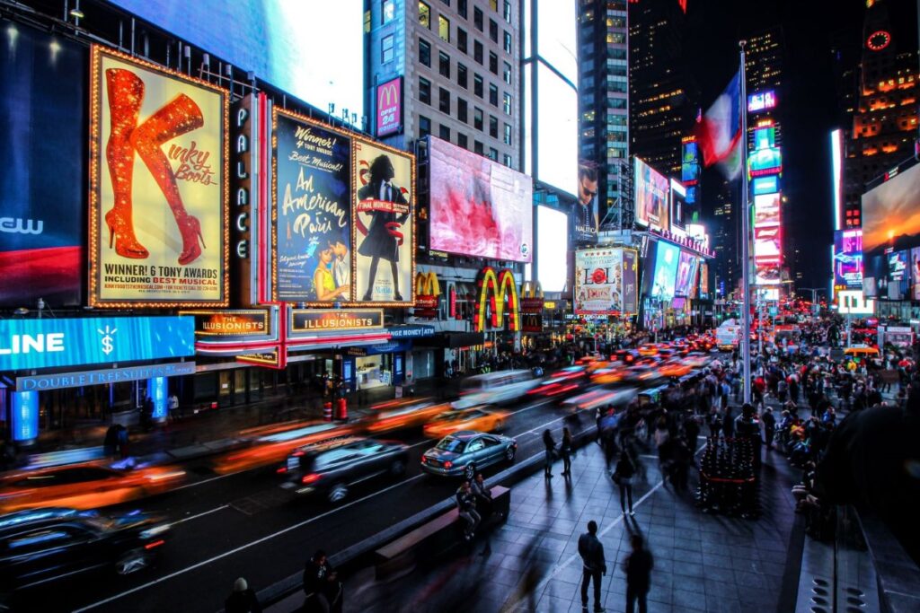 Busy New York street with boradway show commercials at night