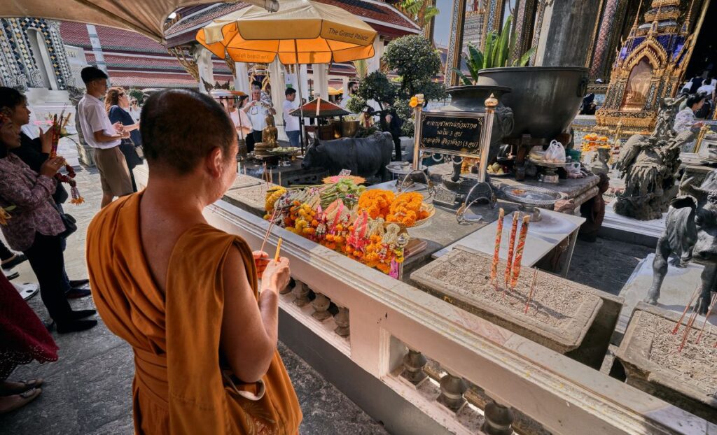 Monk praying in buddhist temple in Thailand